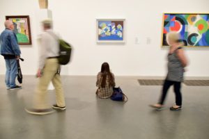Jeune fille assise par terre dans un musée contemplant un tableau