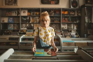 Jeune dans un magasin de disque regardant un album d'Elvis Presley