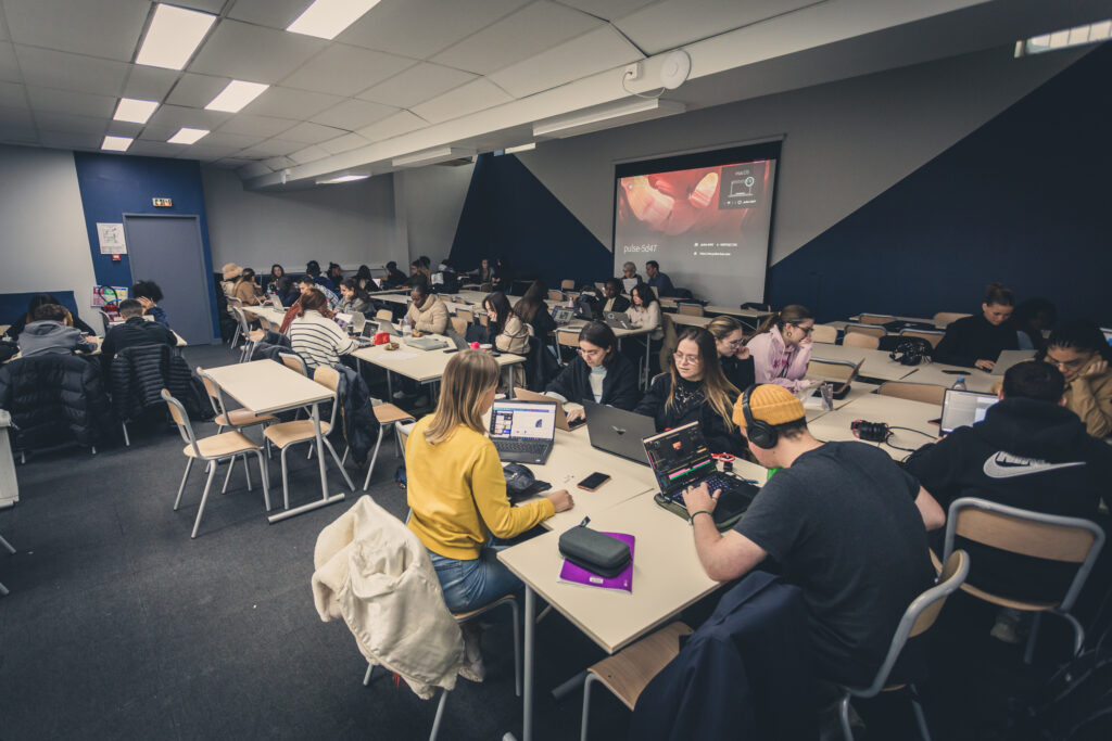 Des étudiants dans une salle de classe en train de travailler sur leurs ordinateurs